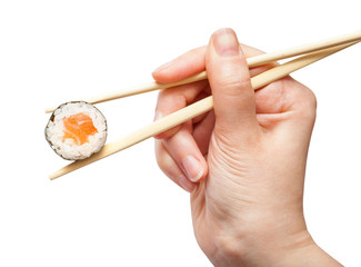 chopsticks hold sake maki roll with salmon fish