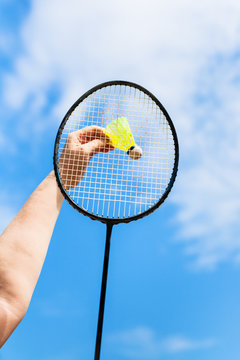 female hand hits shuttlecock by badminton racquet
