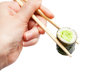 chopsticks hold kappa roll with cucumber close up