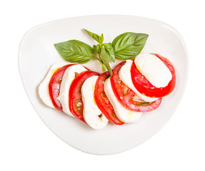 top view of mozzarella and tomato with basil twig