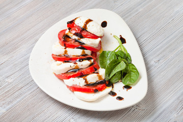 mozzarella cheese and tomato with basil twig