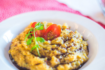 Close up of a fresh polenta with tomatoes. Vegetarian meal.