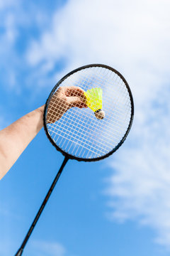 hand strikes shuttlecock by badminton racquet