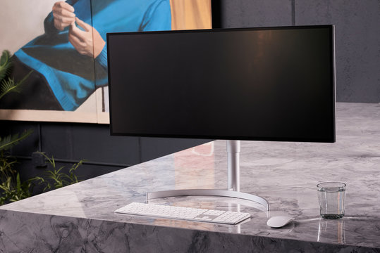 Computer Wide Screen on Marble Counter Table Lifestyle Modern Interior Scene 