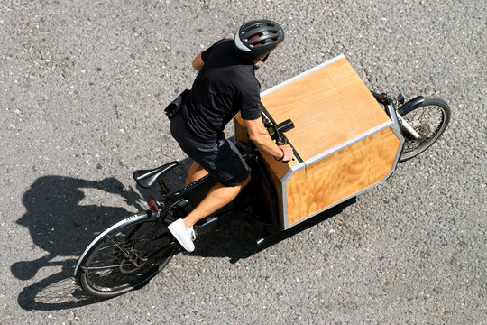 courier delivery cyclist rider with  box for packages in city street