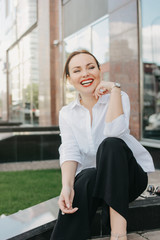 Happy brunette elegant woman business lady in white shirt at city street