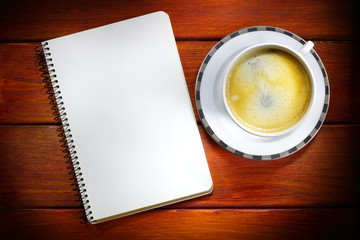 Sketchbook and hot coffee on a red wooden surface