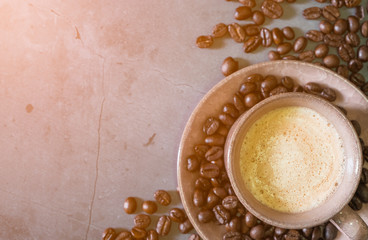 Morning sun light. Cappuccino or latte coffee cup with coffee beans, top view.