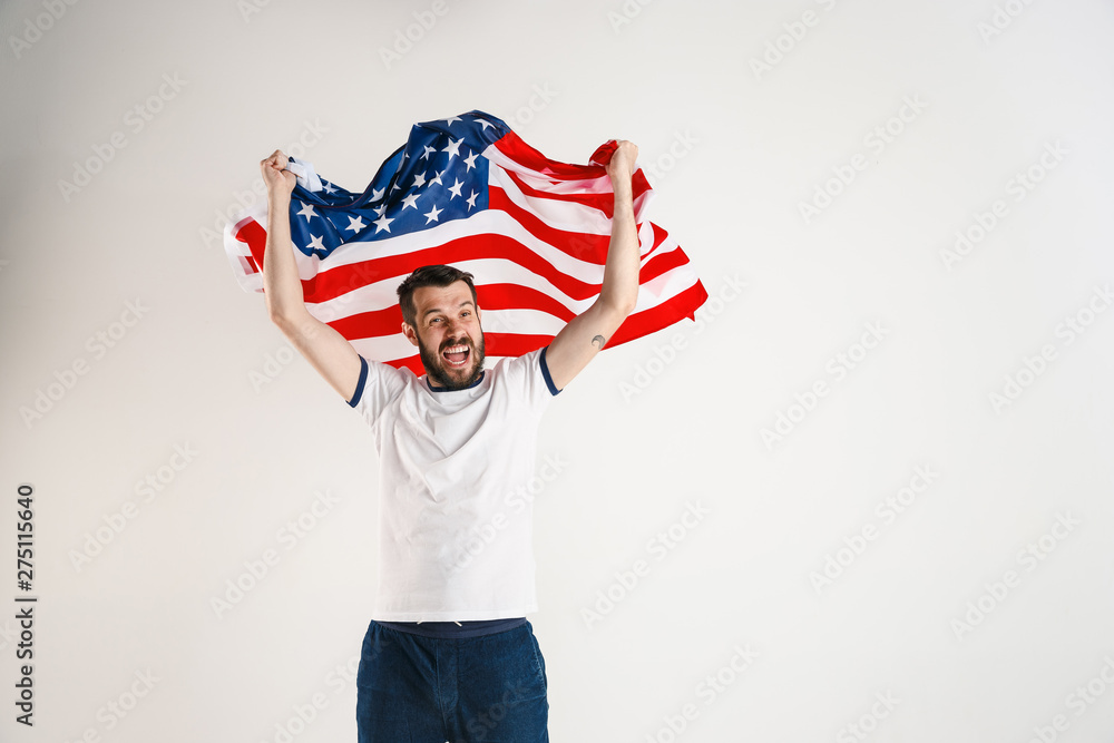 Wall mural celebrating an independence day. stars and stripes. young man with the flag of the united states of 