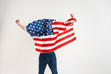Celebrating an Independence day. Stars and Stripes. Young man with the flag of the United States of...