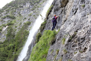 Klettersteig führt duch die Felswand an Wasserfall
