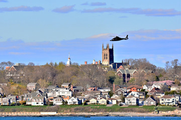 Private helicopter transporting passengers over Newport, Rhode Island