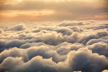 Fotobehang View of the clouds from above at dawn © Nikolay Denisov