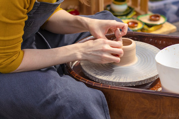 The hands of a woman potter make a vase of clay, selective focus