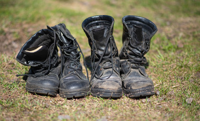 army boots stand in a row on the grass.