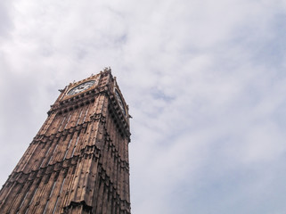Fototapeta na wymiar Big Ben Clock (diagonal angle) in cloudy sky from ground.