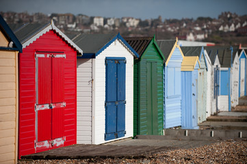 Fototapeta na wymiar A row of coloured British holiday huts lead into the blurred distance. United Kingdom - Image
