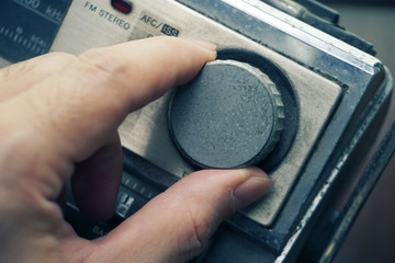 Hand adjust signal tuning of vintage cassette tape dial.