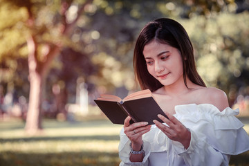 One women in Public park drink coffee and read a book