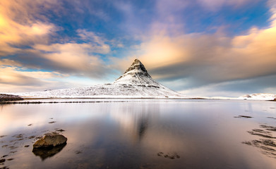 Kirkjufell, Iceland, reflected in still waters in sunset time.