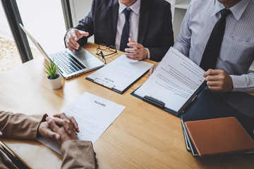 Two selection committee manager reading a resume during a job interview, Employer interviewing to ask young female job seeker for recruitment talking in office