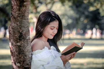 One women in Public park drink coffee and read a book