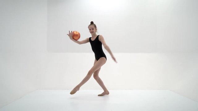 little girl is engaged in fitness with a ball.