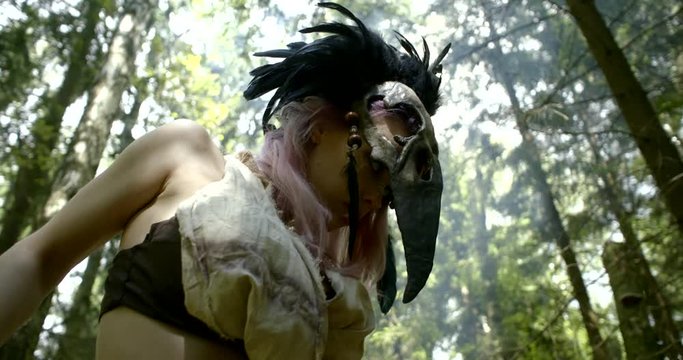 exciting lady in brown shaman clothing takes off mask