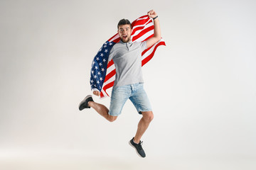 Celebrating an Independence day. Stars and Stripes. Young man with the flag of the United States of...