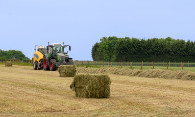 Tractor on farm bailing straw