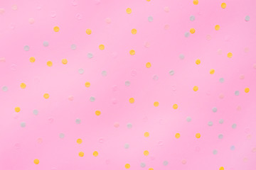 Pink pastel festive background with multicolored confetti. Copy space for your text. Flat lay style. Top view. 