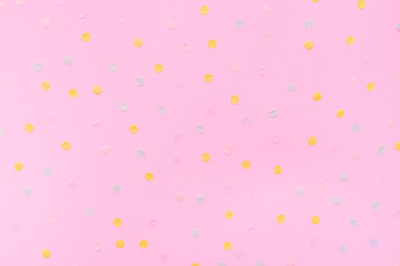 Pink pastel festive background with multicolored confetti. Copy space for your text. Flat lay style. Top view. 