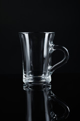 Clean empty glass mug on black background