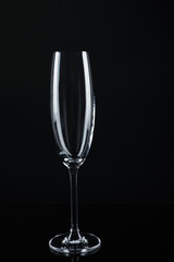 New empty champagne glass on black background