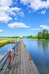 Fototapeta premium Wooden jetty at a canal with lifebuoys