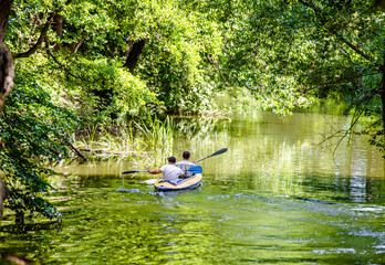 Two men floating in a canoe on the river 
