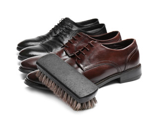Stylish men's shoes and cleaning brush on white background