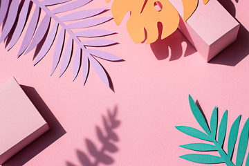 Fototapeta premium Paper tropical plants leaves on the pink background. Summer concept Top view