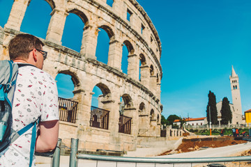Fototapeta na wymiar young man tourist standing near old roman coliseum in pula croatia. tourism concept