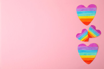 Top view of rainbow hearts on color background, space for text. Gay symbol