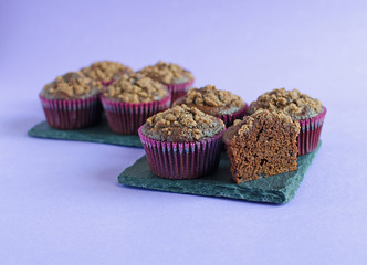 Set of chocolate muffins on black square board on purple background