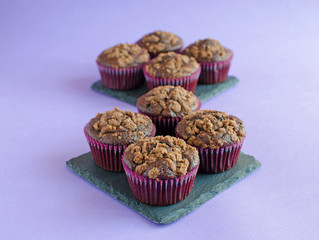 Set of chocolate muffins on black square board on purple background