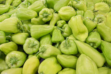 Bulgarian sweet green pepper background close up. pile of green bell peppers as background, texture. Bulgarian pepper on counter in market. soft focus