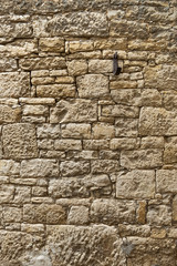 Alte gepflegte Sandsteinmauer aus gelbem Sandstein mit unregelmäßig großen und sehr kleinen...