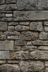 Alte Natursteinmauer aus grauen und gelblichen Steinen in unterschiedlichen Größen