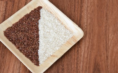 long grain red and white peeled rice on a wooden plate