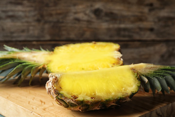 Cut fresh juicy pineapple on wooden board, closeup