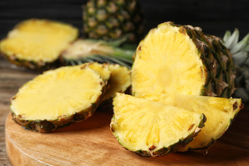 Cut fresh juicy pineapple on wooden board, closeup