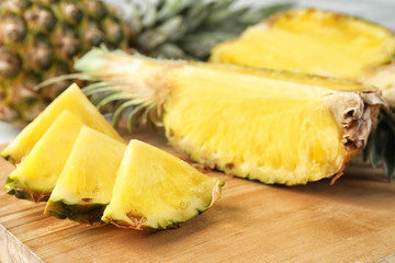 Cut fresh juicy pineapple on wooden board, closeup