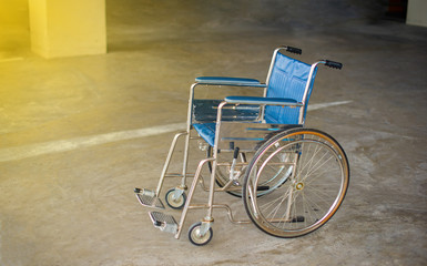 Empty wheelchair on the cement floor in hospital, Wheelchair for patients with dark background,...
